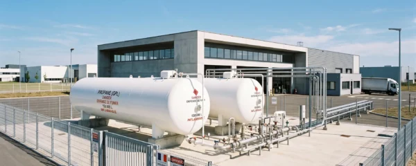 Installation moderne de cuves de stockage propane aériennes sur site industriel français, avec système de canalisations apparent et infrastructure de sécurité conforme aux normes